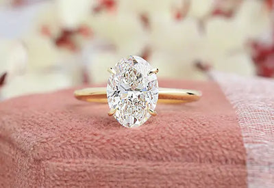 Oval diamond ring for women made with gold and prong setting.