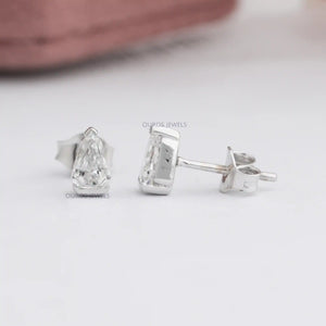 Arrow Cut Stud Diamond Earrings displayed on a white surface, featuring arrow-shaped diamonds in a stylish and modern stud.