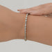 east west set emerald cut lab created diamonds bezel set tennis bracelet in yellow gold on hand