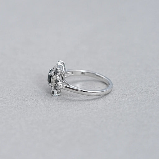 side view of black round lab diamond baguette halo ring on grey fabric