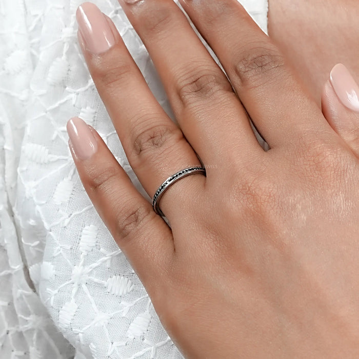 black round-cut diamond channel-set half eternity band engagement ring in finger