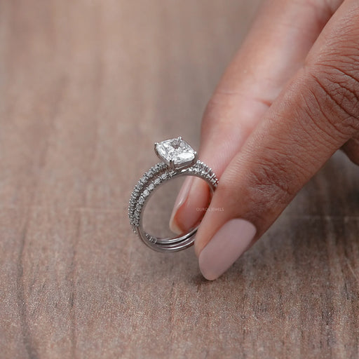 side view of elongated cushion-cut lab diamond bridal ring set on brown background