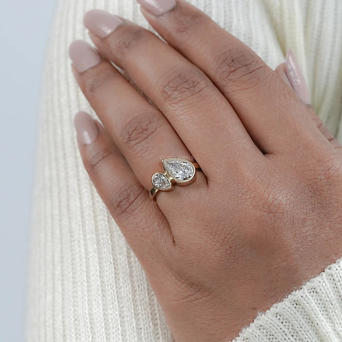 two stone pear shaped lab diamond bezel set engagement ring on model's finger