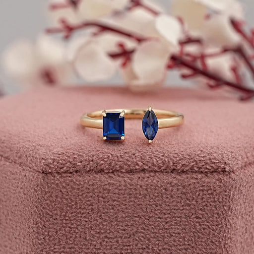 two-stone blue emerald and pear gemstone open wedding ring on jewelry box