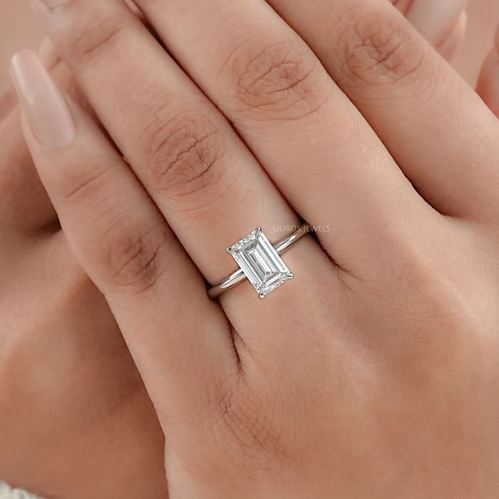 emerald cut lab diamond solitaire engagement ring on model's hand