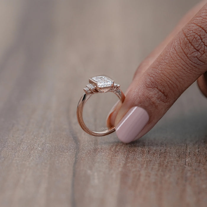 side view of emerald-cut diamond half bezel set solitaire accent engagement ring