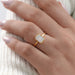 emerald cut bezel set diamond engagement ring shining on hand view