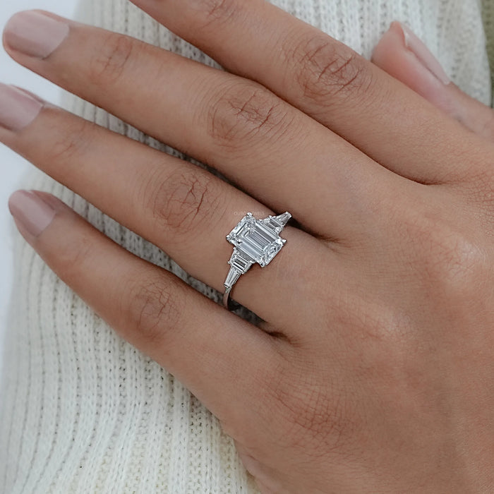 emerald cut and trapezoid lab diamond five stone engagement ring on model's finger