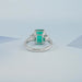 back view of green emerald gemstone with trapezoid diamond 3 stone engagement ring