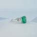 right view of emerald gemstone and bullet-cut diamond three-stone engagement ring