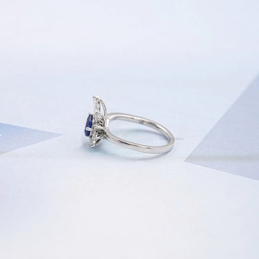 left view of pear cut blue sapphire gemstone cluster bypass engagement ring