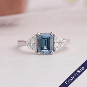 Blue emerald cut lab grown diamond three stone engagement ring in 14k white gold