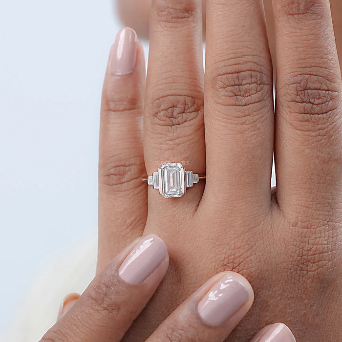 front view of emerald-cut diamond half bezel set solitaire engagement ring in finger