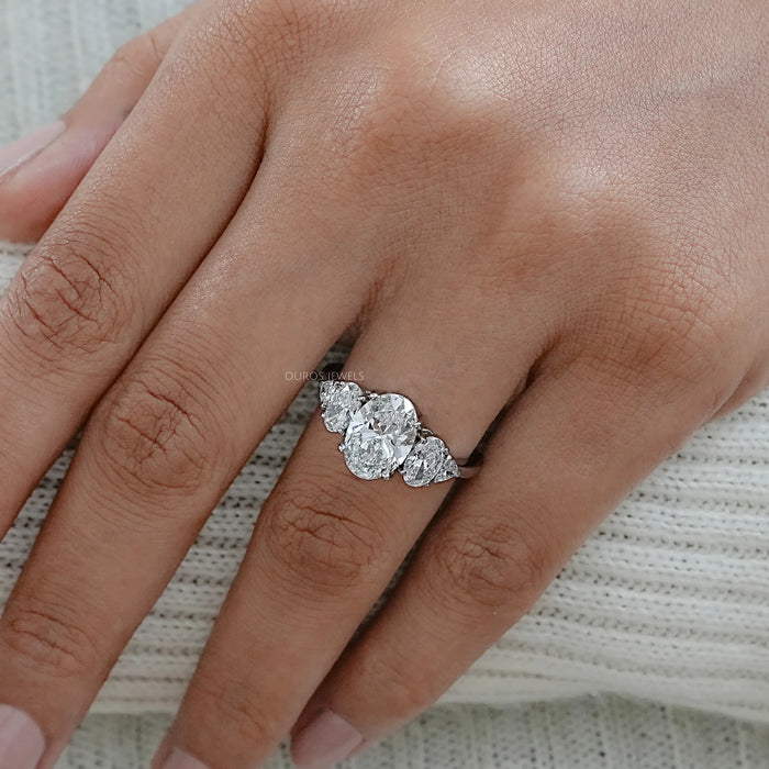 oval and trillion cut lab diamond five stone engagement ring in finger
