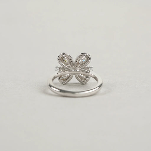 back view of olive pear cut diamond floral halo engagement ring on grey fabric