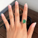 cushion-cut gemstone emerald-shaped band solitaire engagement ring in finger