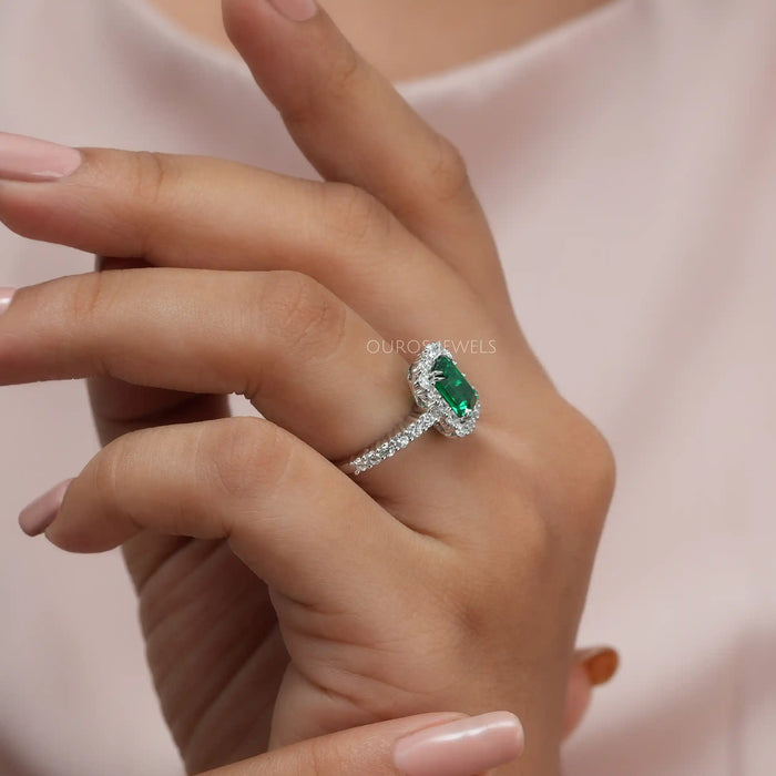 women weared emerald cut halo engagement ring 