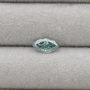 1.23 Carat Green Marquise Cut Loose Diamond placed on a light gray fabric background.