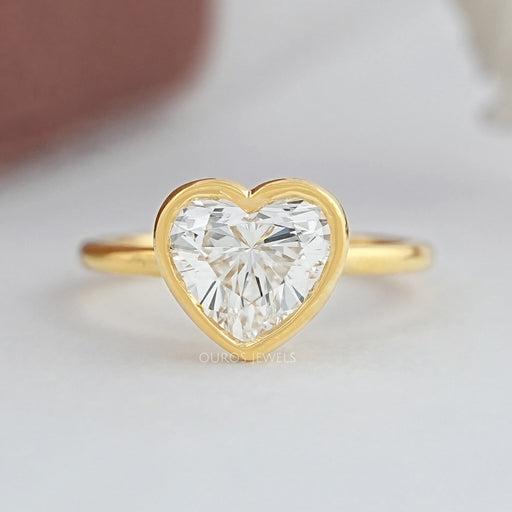 heart shape diamond bezel set solitaire engagement ring in yellow gold band
