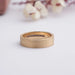 Mens Brushed Gold Ring laying flat, featuring a sleek brushed gold finish with a row of small diamonds set inside.