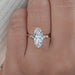front view of moval cut lab diamond solitaire accent engagement ring in finger