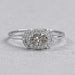 oval diamond halo engagement ring with olive center stone view on grey background