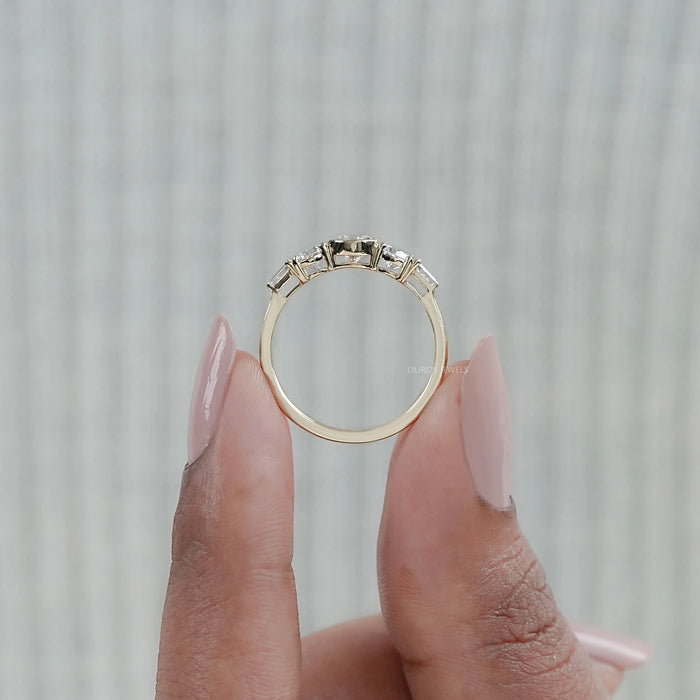 close view of round and tapered baguette diamond half bezel five stone engagement ring