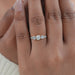 round and baguette diamond half bezel five stone engagement ring in finger