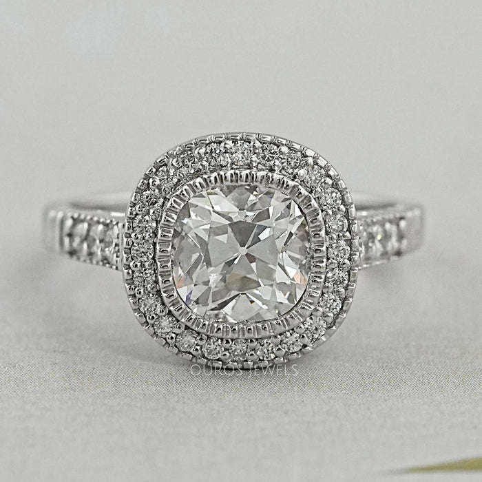 old mine cushion diamond halo engagement ring's front view on grey background
