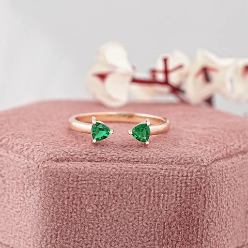 trillion-cut green gemstone open cuff toi et moi wedding ring on jewelry box