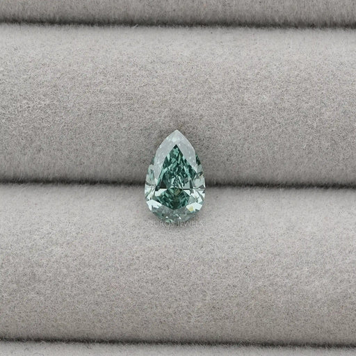 1.62 Carat Fancy Vivid Green Pear Cut Lab Grown Diamond displayed on a light grey fabric background.