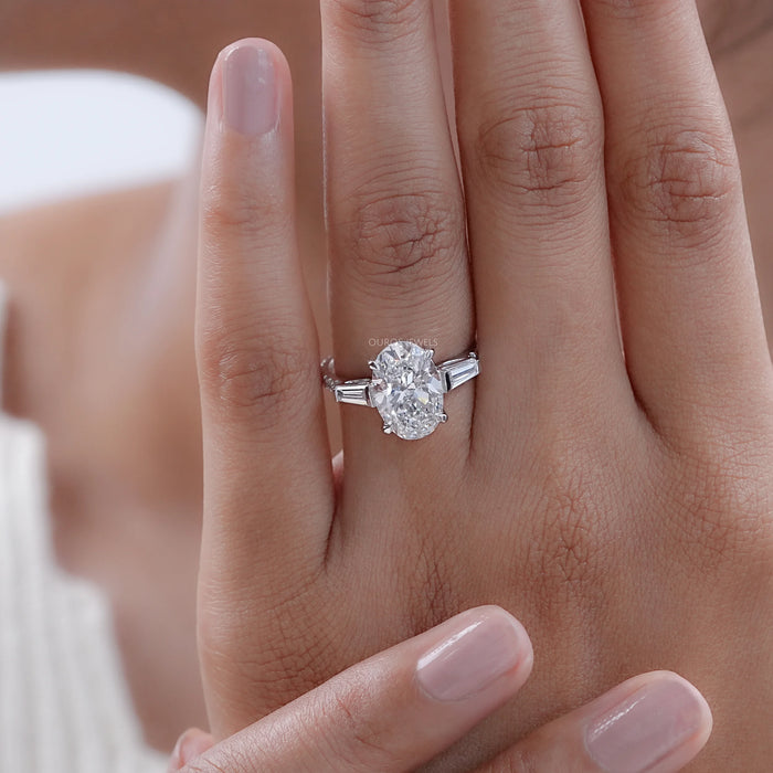 oval cut lab diamond three stone engagement ring in finger