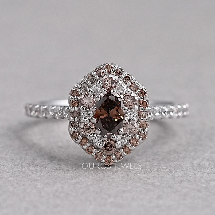 top view of oval cut brown diamond double halo engagement ring on grey fabric