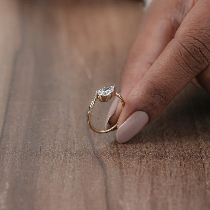 side view of pear cut lab diamond curved solitaire engagement ring