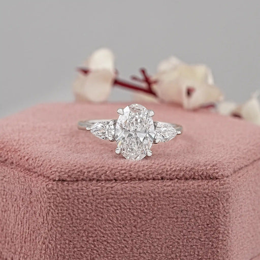 oval shape lab grown diamond three stone engagement ring on jewelry box