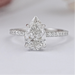 front view of pear-shaped lab diamond solitaire accent ring on grey fabric