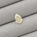 2.17 Carat Fancy Yellow Pear Cut Loose Diamond displayed on a gray cushioned surface, showcasing its elegant shape and yellow color.