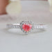 top view of pink heart cut diamond halo engagement ring on grey fabric