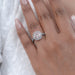 pink round-cut lab diamond solitaire halo engagement ring on model's finger