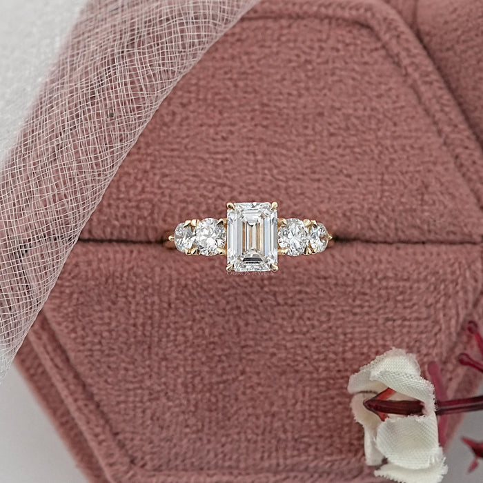 emerald cut and round lab diamond five stone engagement ring in jewelry box