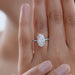oval-cut lab grown diamond solitaire accent engagement ring on model's finger