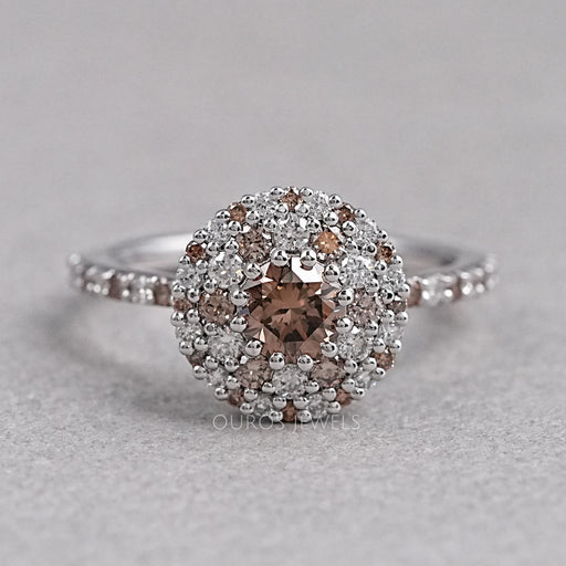 top view of brown round shape diamond cluster halo engagement ring on grey fabric