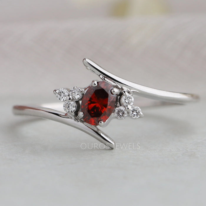 front view of red oval-cut lab-grown diamond bypass colored wedding band
