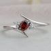 front view of red oval-cut lab-grown diamond bypass colored wedding band