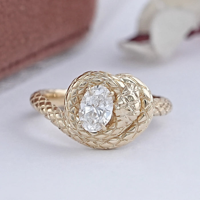 front view of snake-shaped oval-cut diamond anniversary ring with yellow gold band