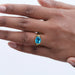east west blue oval cut gemstone wedding ring in finger