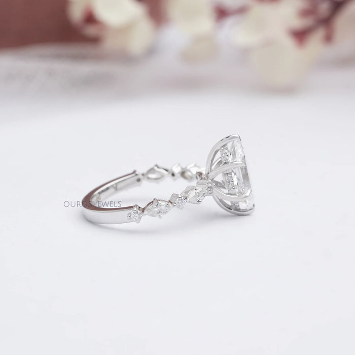 side view of dutch marquise cut and solitaire accent diamond ring on grey fabric