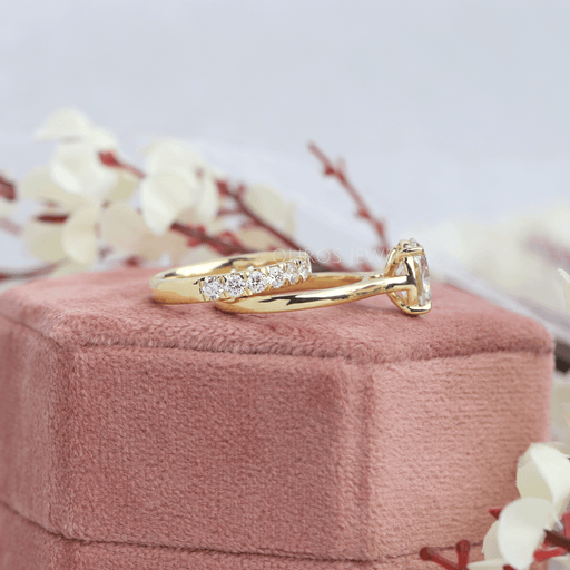 side view of oval cut diamond bridal ring set with yellow gold band on jewelry box