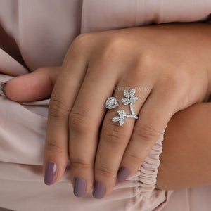 In finger front view of pear shaped diamond ring set in halo. This floral style open cuff ring made in 14k white gold.