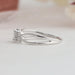 Side view of emerald cut cluster diamond ring with round cut side diamonds.